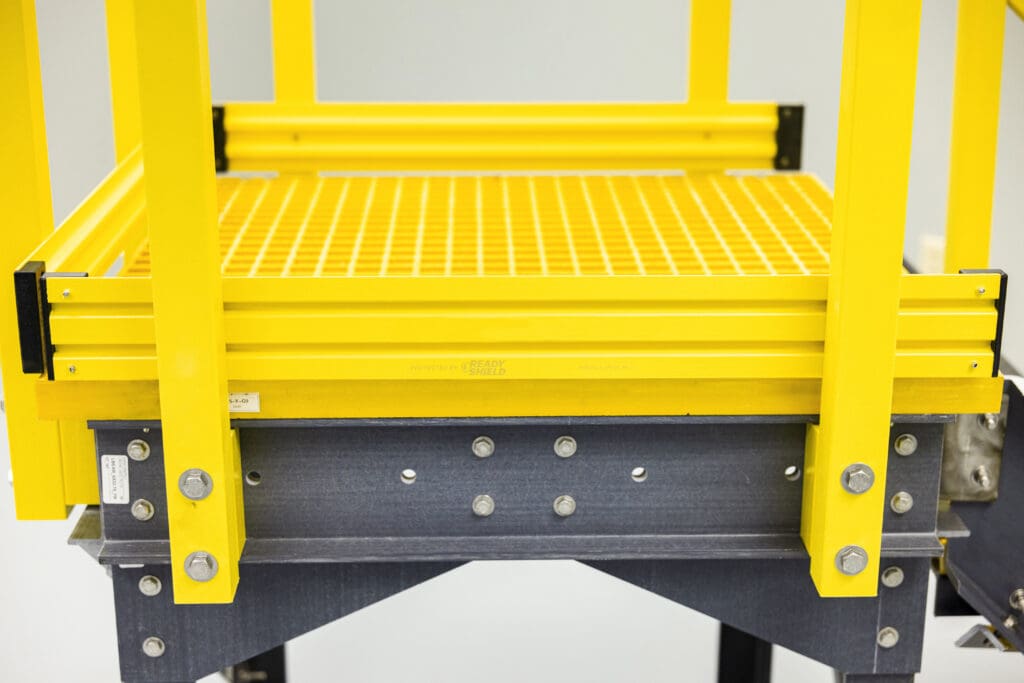 Yellow platform with railing bolted in, slightly zoomed out