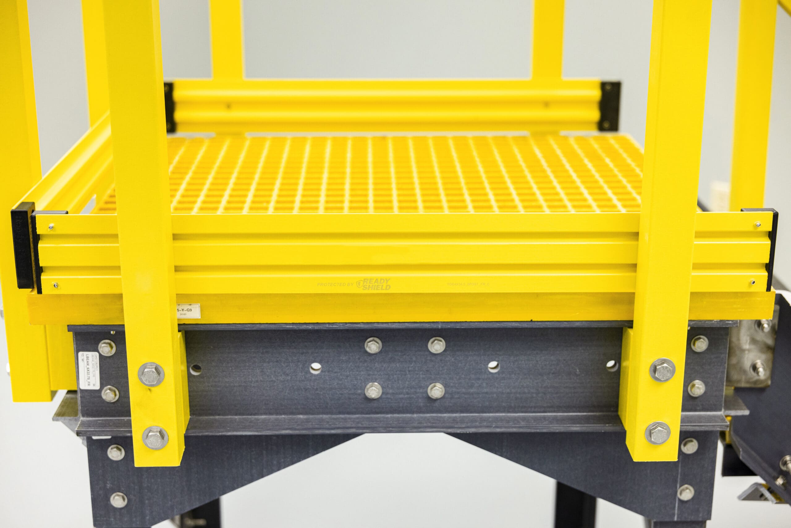 Yellow platform with railing bolted in, slightly zoomed out