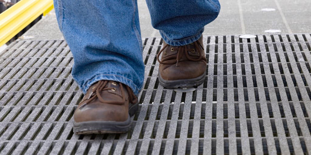 Close up image of boots walking on FRP platform.