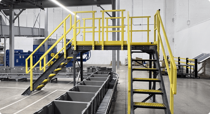 Crossover stairs crossing over an industrial conveyor belt