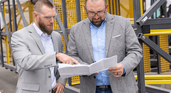 Two men reviewing a technical document
