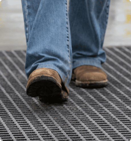 Up-close image of worker walking on a molded grating platform