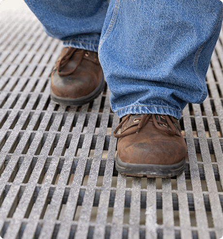 Up-close image of worker walking on a pultruded grating platform