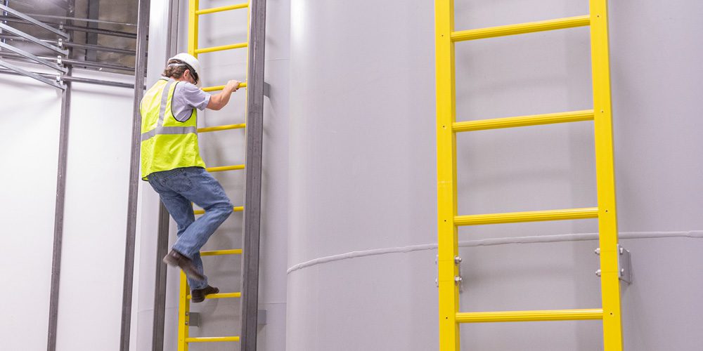 Worker climbs OSCO safety ladders