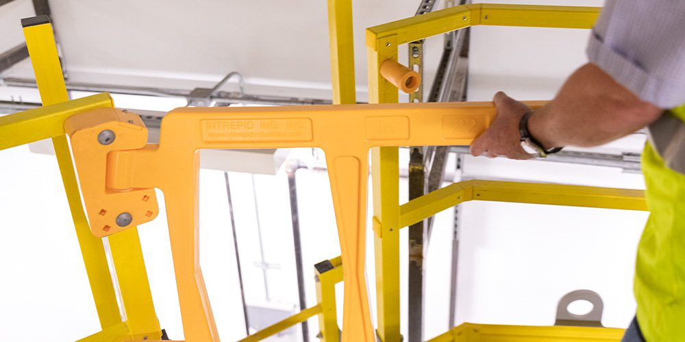 Worker opening a yellow safety gate.